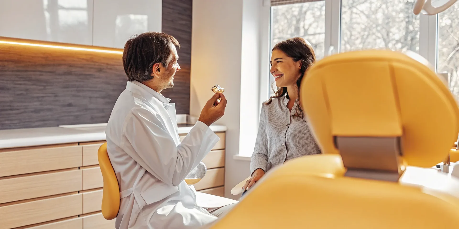 Dentist explaining a single tooth implant and dental bridge
