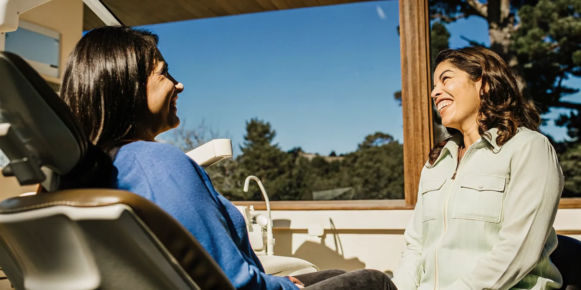 Patient smiling during a cosmetic dentistry consultation in a bright modern dental office