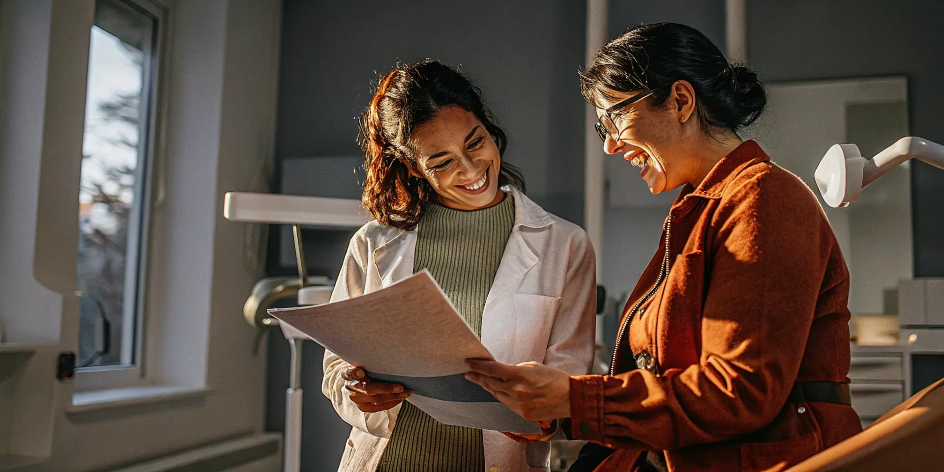 Dental patient discussing insurance paperwork with a dentist in a modern Lowell MA dental office